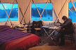Yurta interior showcasing a comfortable sleeping area and seating with natural wood accents and warm.